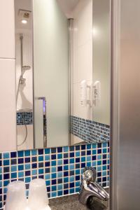 a bathroom with a sink and a mirror at Holiday Inn Express Toulouse Airport by IHG in Blagnac