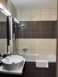 Hotel Crocus في ستربشكي بليسو: حمام مع حوض وحوض استحمام