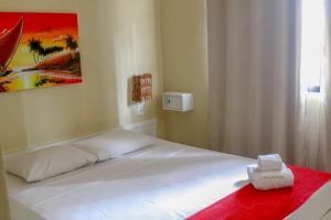 1 dormitorio con cama blanca y manta roja en El Dorado Hotel Fortaleza, en Fortaleza