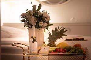 a vase with flowers and fruit on a table at Diamond Prywatny Basen & Sauna Apartament Poznań in Poznań