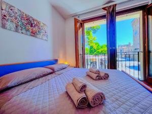 a bedroom with a large bed with towels on it at Tra Onde & Vicoli - Parcheggio PRIVATO in Porto Recanati