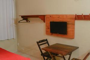 Habitación con mesa y TV en la pared. en El Dorado Hotel Fortaleza, en Fortaleza