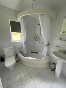 a bathroom with a tub and a toilet and a sink at Gleneagles Rental in Auchterarder +12 photos