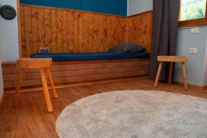 a room with a bed and two chairs and a rug at Apartma Burk in Kobarid