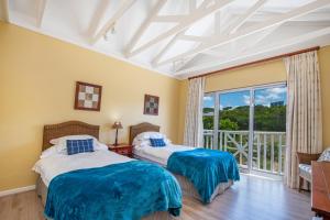 two beds in a room with a balcony at Luxury Lodge at Pinnacle Point in Mossel Bay
