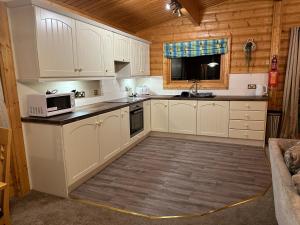a kitchen with white cabinets and a microwave at Bamboo Retreat in Louth