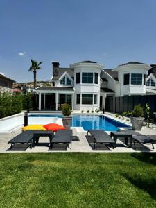 a large house with a swimming pool and a house at Sunken seated fire pit villa! in Foça