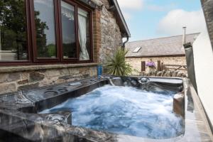 a hot tub in the backyard of a house at Ivy Cottage in Pyle