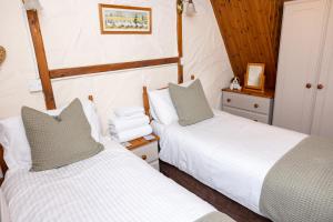 two beds in a small room with at Ivy Cottage in Pyle +11 photos