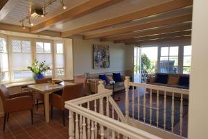a living room with chairs and tables and windows at Heefwai 2 W1 in Morsum