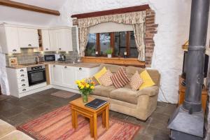 a living room with a couch and a stove at Ivy Cottage in Pyle