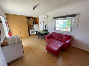 a living room with a red couch and a table at Casa vista dos cerros in Loulé