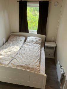 a small bedroom with a bed and a window at Sentrums leilighet in Kabelvåg