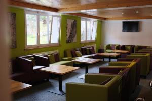 a restaurant with green walls and tables and windows at Eiger Lodge Easy in Grindelwald