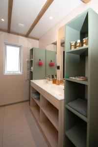 La salle de bains est pourvue d'un lavabo et d'un miroir. dans l'établissement Parc Saint James Oasis Village, à Puget-sur Argens
