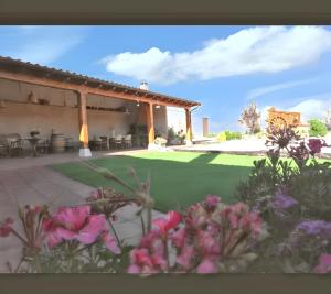un patio avec une cour fleurie au premier plan dans l'établissement 3 bedrooms house with enclosed garden at Peral de Arlanza, à Peral de Arlanza