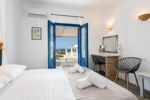 1 dormitorio con cama, lavabo y espejo en Naoussa Hotel Paros by Booking Kottas, en Naousa