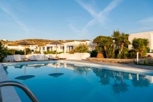 una piscina de agua azul en una villa en Naoussa Hotel Paros by Booking Kottas en Náousa