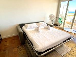 ein großes Bett in einem Zimmer mit einem großen Fenster in der Unterkunft Large flat terrace Sea view, Promenade des Anglais in Nizza