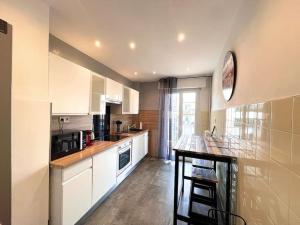 eine Küche mit weißen Schränken und einer Arbeitsplatte in der Unterkunft Large flat terrace Sea view, Promenade des Anglais in Nizza