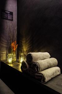 una pila de toallas sentadas en una mesa con velas en Les Pardines 1819 Mountain suites & SPA en Encamp