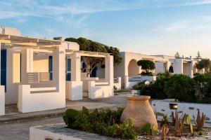 una casa blanca con un jarrón delante en Naoussa Hotel Paros by Booking Kottas, en Naousa