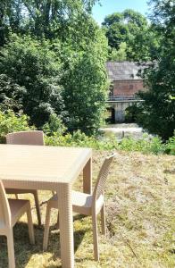 drewniany stół i krzesła na dziedzińcu w obiekcie New appartement nature cœur de ville w mieście Avesnes-sur-Helpe
