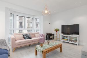 a living room with a couch and a tv at Apartamento Villabona - Mar y Montaña Elegante Apt p8 con WiFi gratis in Villabona