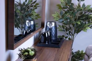 a table with two vases on a shelf with plants at شقق الجود in Medina