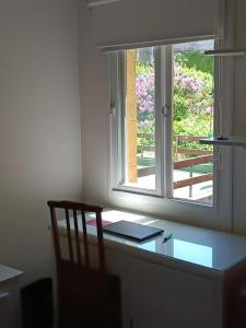 a desk with a window in a room with a chair at La casa de María in Buenos Aires