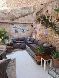 eine Terrasse mit Sofa, Tischen und Pflanzen in der Unterkunft Maison du Coquelicot in Tourouzelle