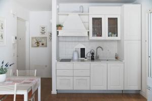 a kitchen with white cabinets and a sink at Casa Talo in Arco