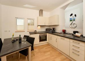 een keuken met witte kasten en een tafel met stoelen bij Landküche - Ferienwohnung in Daun