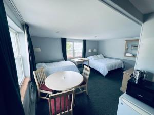 um quarto com duas camas e uma mesa e cadeiras em Harbor Landing Resort em Vineyard Haven