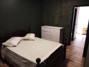 a bedroom with a bed and a dresser and a window at Apartamento aconchegante de montanha in São Roque