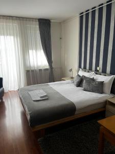 um quarto com uma cama grande e uma janela em Garni hotel BELVEDERE LUX em Kraljevo