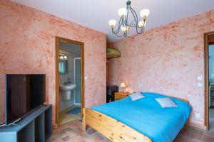 a bedroom with a bed and a flat screen tv at Les Sylphides - Maison avec piscine in Montélimar +6 photos