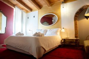 1 dormitorio con cama blanca y espejo en Ca' Vendramin - Letters To Juliet, en Verona