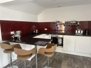 a kitchen with a black counter and stools in it at Studio - Sleeps 2 - Pets - Parking - Wifi in York