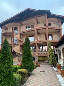 a large building with trees in front of it at Vila Rafael si Robert in 2 Mai +19 photos