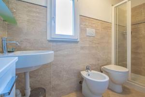 a bathroom with a white sink and a toilet at La Terrazza sul mare in Porto Azzurro +38 photos