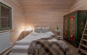 two beds in a room with wooden walls at Karak Chalet in Izvoare