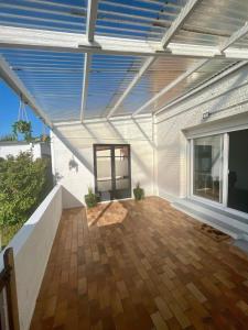 eine überdachte Terrasse mit Holzboden in der Unterkunft Maison contemporaine proche de Lille in Saint-André