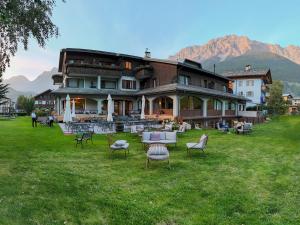 a large building with chairs and tables in a field at Hotel Nevada in Bormio