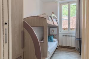 a small bedroom with a bunk bed with a window at Appartamento Il Borgo in Bellagio