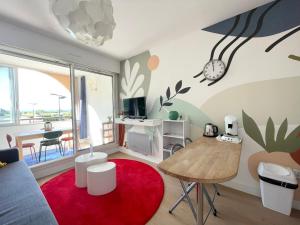 un salon avec une table et un tapis rouge dans l'établissement STUDIO VUE MER Quartier des Quilles, à Sète