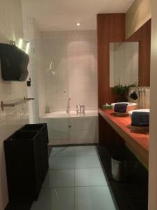 W łazience znajduje się wanna, umywalka i lustro. w obiekcie Wellness Dome Penthouse w mieście Kerkrade