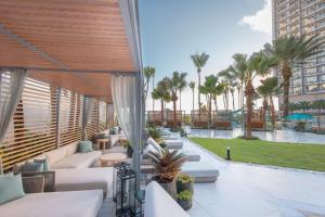 un patio con mobili bianchi e palme di San Juan Marriott Resort and Stellaris Casino a San Juan