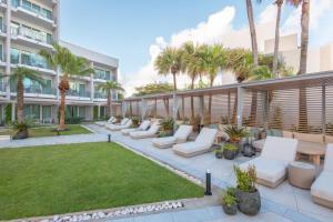 a patio with white furniture and palm trees at San Juan Marriott Resort and Stellaris Casino in San Juan