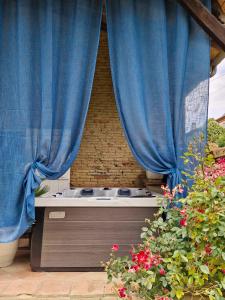einen Whirlpool in einem Zimmer mit einem blauen Vorhang in der Unterkunft Domaine Le Clos du Figuier Spa in Verdun-sur-Garonne